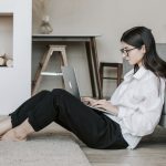 Femme travaillant à distance dans son salon avec un ordinateur portable, illustration du télétravail et de la flexibilité professionnelle