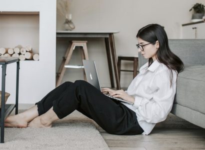 Femme travaillant à distance dans son salon avec un ordinateur portable, illustration du télétravail et de la flexibilité professionnelle