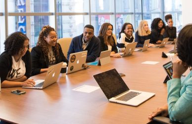 Collègues autour d'une table de réunion avec des ordinateurs portables lors d'une discussion en équipe